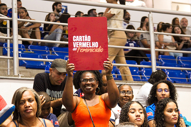 Torcedora apoia a campanha segurando placa na qual se lê Cartão Vermelho ao Feminicídio